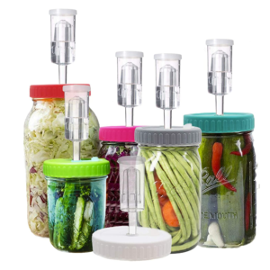 mason jars with different colours of lids with airlocks, containing various vegetables