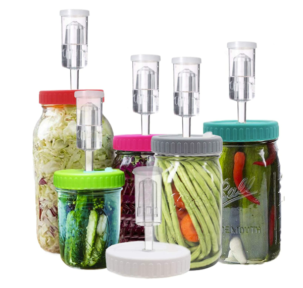 mason jars with different colours of lids with airlocks, containing various vegetables