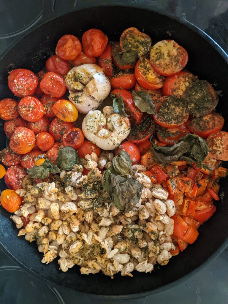 pan full of roasted tomatoes, garlic, peppers, and beans