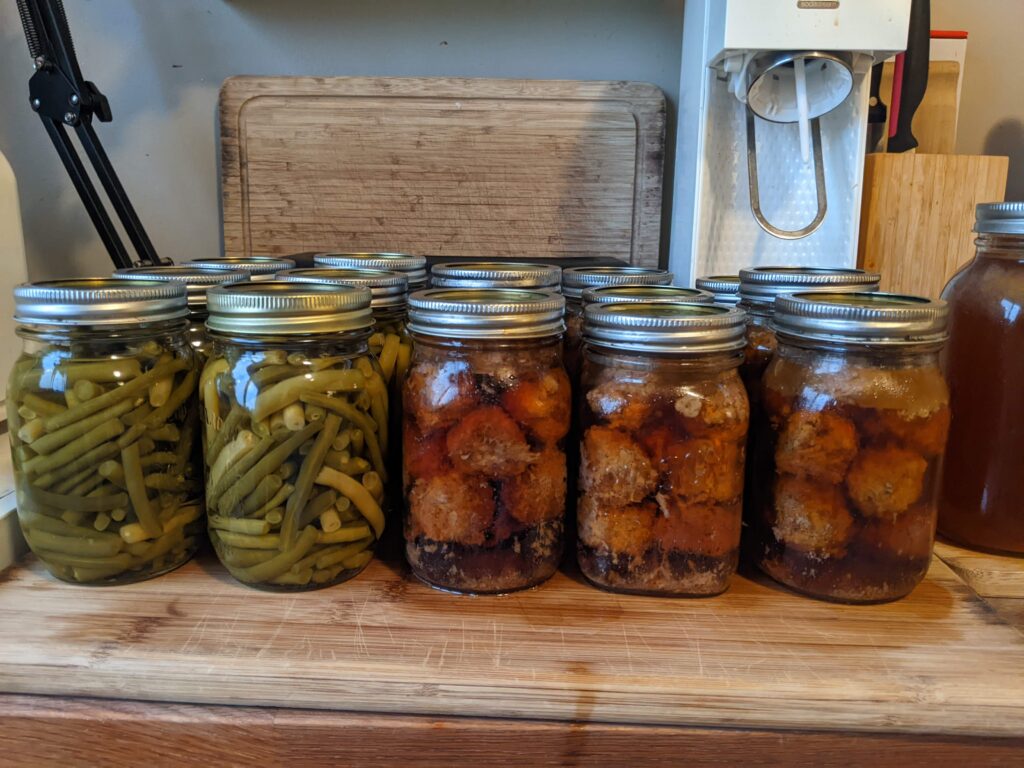 Jars of home canned green beans and jars of home canned meatballs