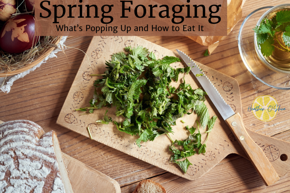 A rustic wooden table set for a spring foraging meal. A wooden cutting board with intricate carvings holds freshly chopped stinging nettles, with a serrated knife resting beside them. A glass cup of herbal tea with floating nettle leaves is nearby. To the left, a loaf of artisanal bread sits on another wooden board, and a basket with decorated eggs and straw is visible in the background. The text overlay reads 'Spring Foraging: What’s Popping Up and How to Eat It.